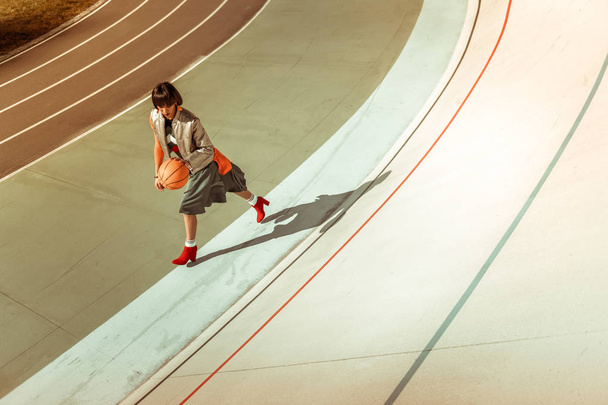 Menina internacional ativa correndo com grande bola
 - Foto, Imagem