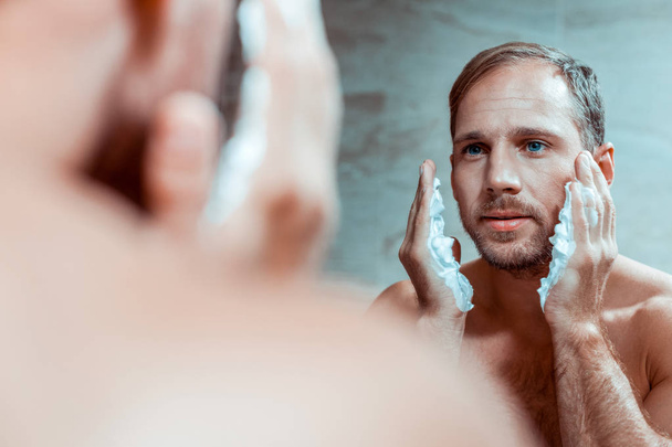 Concentrated man having morning procedures in a bathroom - Foto, afbeelding
