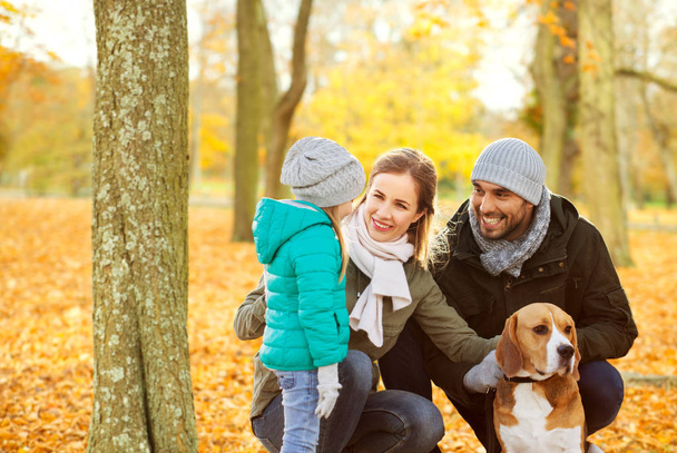 happy family with beagle dog in autumn park - Photo, Image