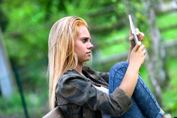 Спантеличена молода жінка дивиться на планшетний комп'ютер
 - Фото, зображення