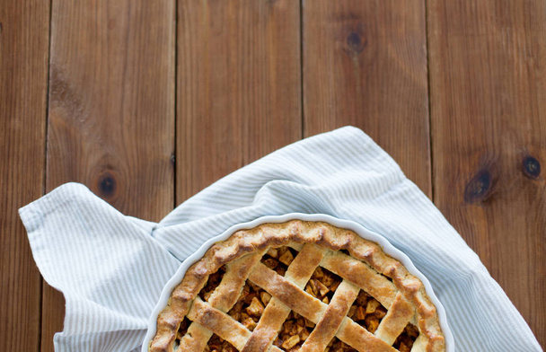 close up of apple pie in mold on wooden table - Φωτογραφία, εικόνα