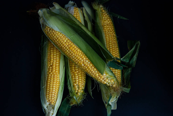 Yellow sweet raw corn on a black background - Фото, зображення