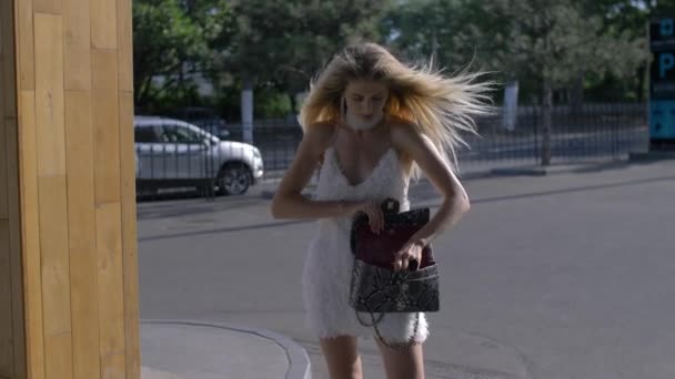Moda dziewczyna grzebać w jej torebce - Materiał filmowy, wideo