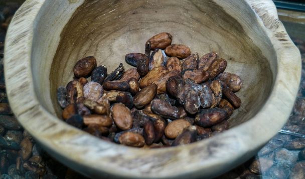 Какао-бобы на деревянной чаше
. - Фото, изображение
