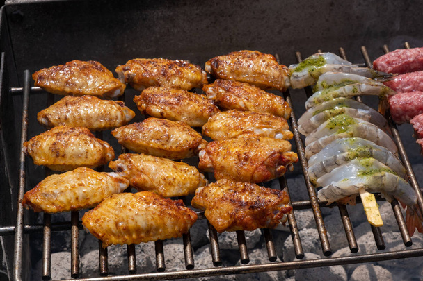 Mieszany asortyment marynowanych mięs, kurczaka i krewetek grillowanie na gorących węgle na grilla - Zdjęcie, obraz