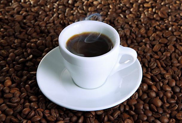 Cup of coffee on coffee beans background - Foto, imagen
