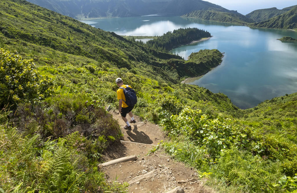 Man Hiking down to Lagoa do Fogo or Lake of Fire in Sao Miguel, Azores, Portugal - Photo, Image
