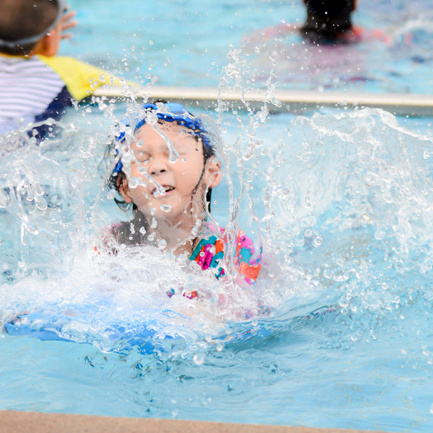Menina asiática desfocada vestindo óculos e desfrutando na piscina, estilo de vida
 - Foto, Imagem