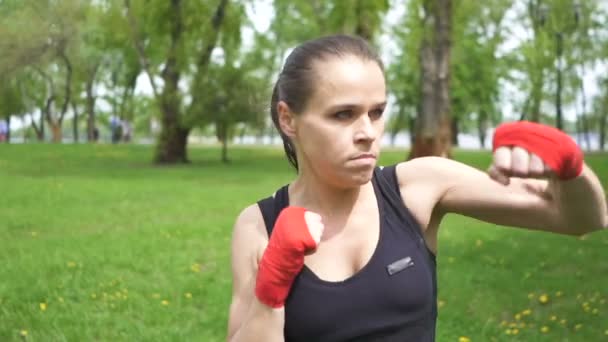Grave allenamento da pugile donna con sacchi da boxe sul campo di allenamento della città di strada, colpo costante
 - Filmati, video