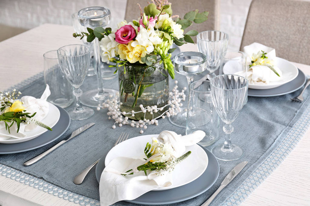 Красива обстановка столу зі свіжими квітами фрезії
 - Фото, зображення