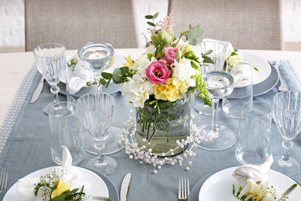Красивая сервировка стола со свежими цветами фрезии
 - Фото, изображение