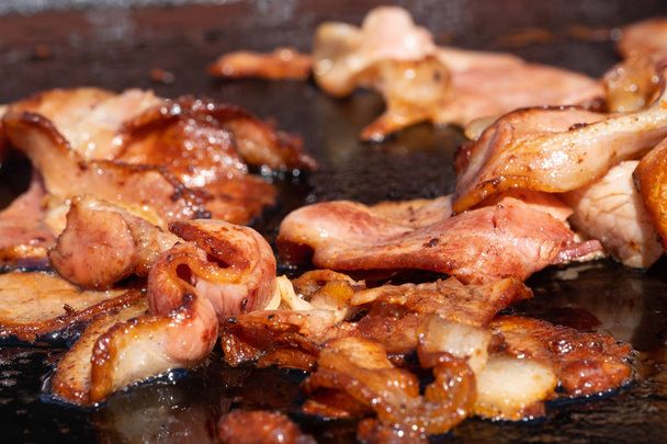 Close-up afbeelding van een kook spek op een barbecue op een school fundr - Foto, afbeelding