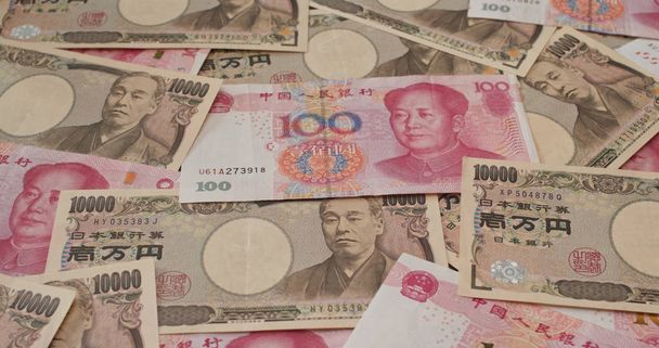 Pila de billetes de RMB chino y Yen japonés
 - Foto, imagen