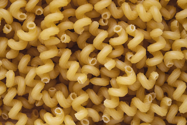 Vista dall'alto della pasta secca italiana spiralli. Maccheroni gialli crudi per sfondo
. - Foto, immagini