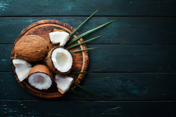 Fresh coconut on a black background. Tropical Fruits. Nut. Top view. Free space for your text. - Foto, Imagem
