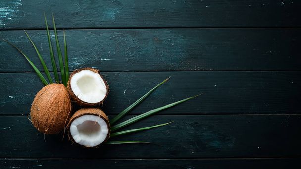 Fresh coconut on a black background. Tropical Fruits. Nut. Top view. Free space for your text. - Valokuva, kuva