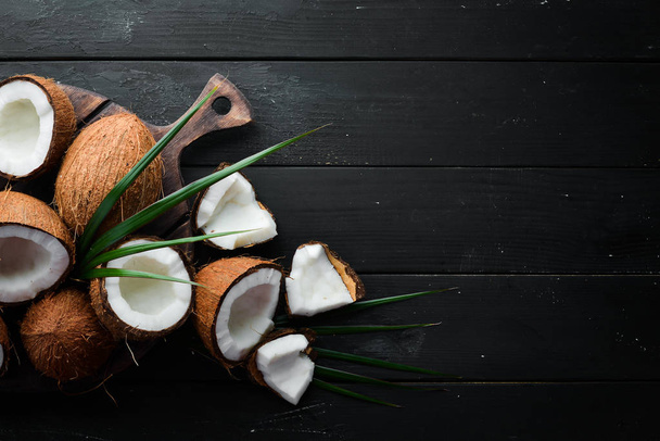 Fresh coconut on a black background. Tropical Fruits. Nut. Top view. Free space for your text. - Foto, afbeelding