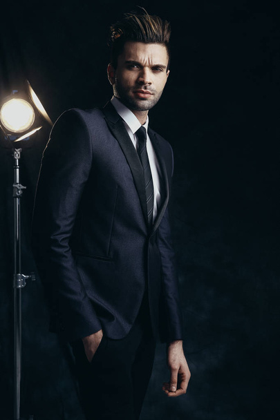 Fashion male portrait in a studio. Formal black suit. - Photo, Image