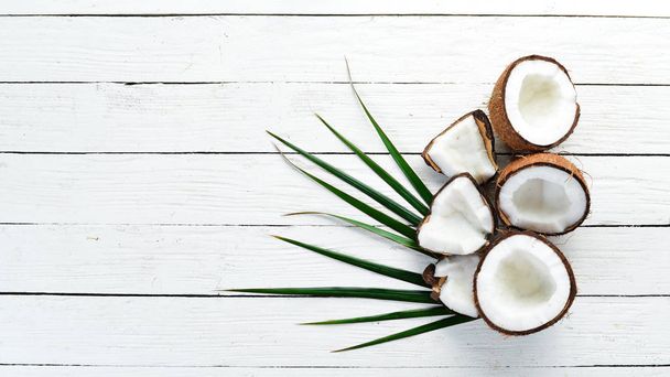 Fresh coconut on a white wooden background. Tropical Fruits. Nut. Top view. Free space for your text. - Fotografie, Obrázek