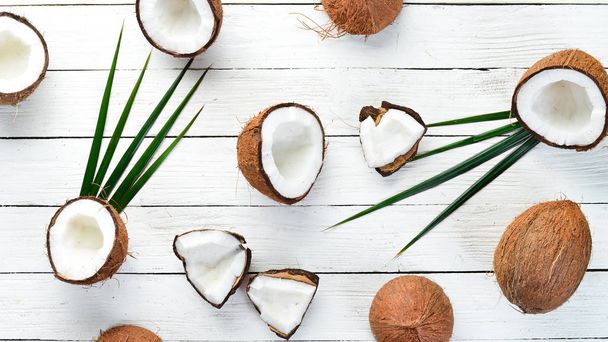 Fresh coconut on a white wooden background. Tropical Fruits. Nut. Top view. Free space for your text. - Photo, image