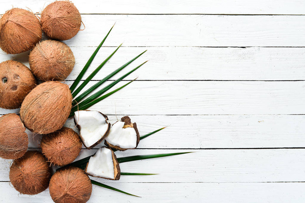 Fresh coconut on a white wooden background. Tropical Fruits. Nut. Top view. Free space for your text. - Fotografie, Obrázek