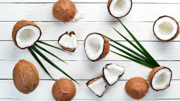 Fresh coconut on a white wooden background. Tropical Fruits. Nut. Top view. Free space for your text. - Fotoğraf, Görsel