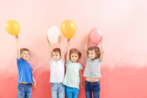 Lindos niños pequeños con globos de aire en el fondo de color
 - Foto, Imagen