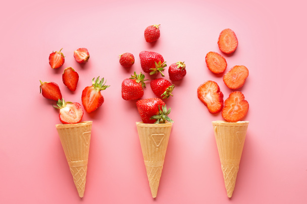 Waffle cones with ripe red strawberry on color background - Photo, Image
