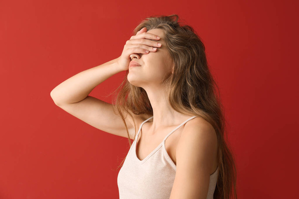 Young woman covering her eyes on color background - Photo, Image