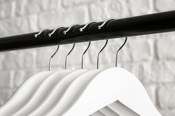 Rack with clothes hangers on white background, closeup - Photo, Image