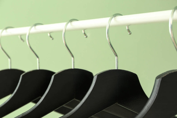 Rack with clothes hangers on color background, closeup - Photo, Image