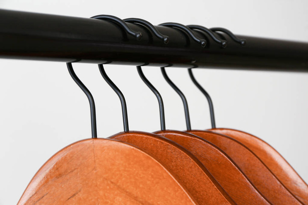 Rack with clothes hangers on light background, closeup - Photo, Image