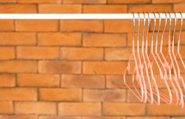 Rack with clothes hangers against brick wall - Photo, Image