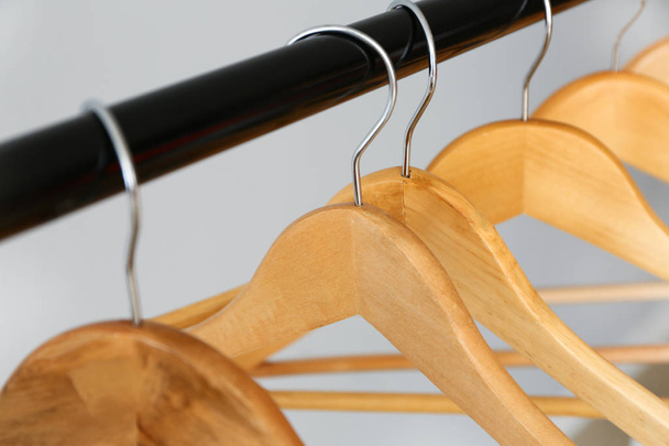 Rack with clothes hangers on light background, closeup - Fotoğraf, Görsel