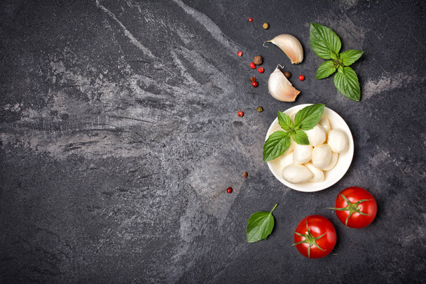 Small balls mozzarella cheese with Cherry tomatoes, garlic and basil - Foto, afbeelding