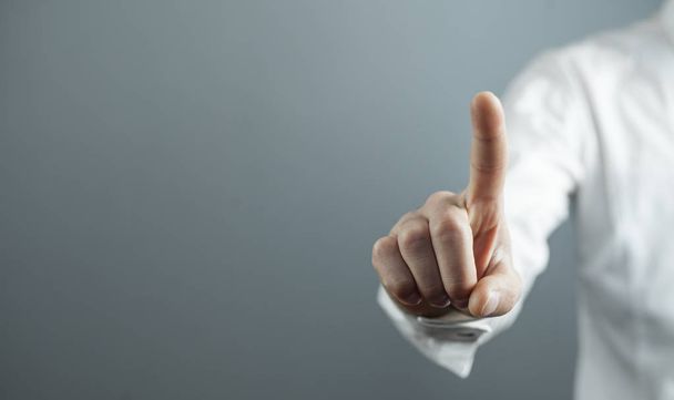 Бизнесмен, указывающий или трогающий палец на экране
.  - Фото, изображение