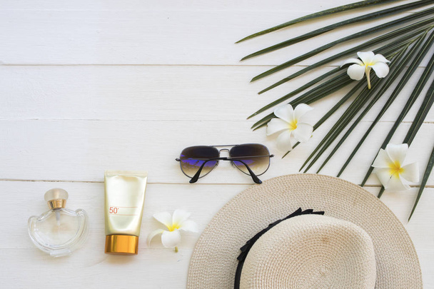 natural cosmetics sunscreen spf50 health care for skin face with sunglasses ,hat ,perfume of lifestyle woman relax summer and flower frangipani ,coconut leaf arrangement flat lay style on background white  - Photo, Image