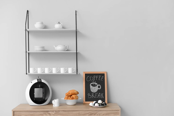 Modern coffee machine and croissants on kitchen table - Фото, изображение