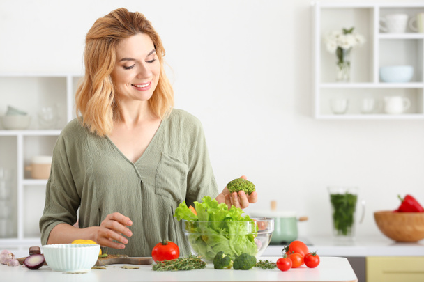 Kobieta robi zdrowe sałatki warzywne w kuchni - Zdjęcie, obraz