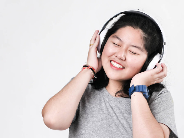 Happy Asian teenager girl using headphone and listening music. - Zdjęcie, obraz