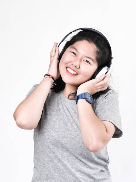 Feliz asiática adolescente chica usando auriculares y escuchar música
. - Foto, imagen