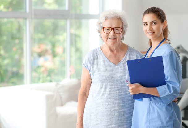 Elderly woman with caregiver in nursing home - Foto, imagen