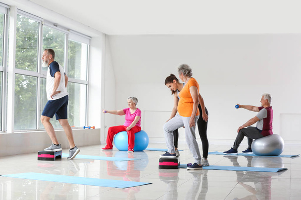 Senioren trainieren mit Trainer im Fitnessstudio - Foto, Bild
