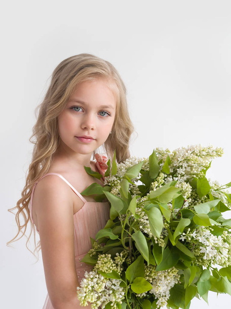 Beautiful girl with a bouquet of lilac closeup - Фото, зображення