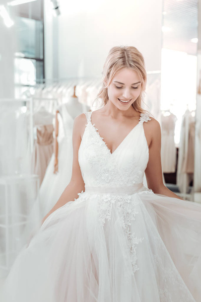 Happy young woman trying on a wedding dress. - Zdjęcie, obraz