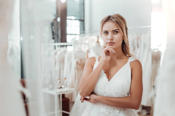 Young woman in a wedding dress looking thoughtful. - Foto, afbeelding