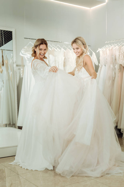 Two brides looking at the dresses of each other. - Фото, зображення