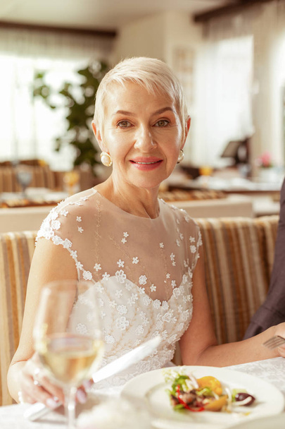 Beautiful aged bride holding glass of champagne - Фото, изображение