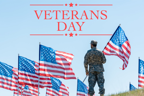 man in military uniform and cap standing and holding american flag with veterans day illustration - Foto, afbeelding