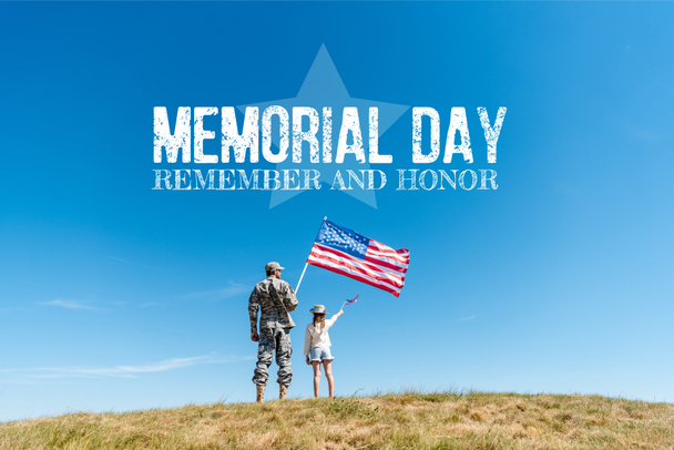 πίσω όψη του παιδιού με ψάθινο καπέλο και στρατιωτικό πατέρα κρατώντας αμερικανικές σημαίες με την ημέρα μνημόσυνο, θυμηθείτε και τιμή εικόνα - Φωτογραφία, εικόνα